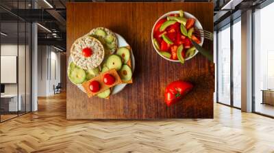 Rice and gluten-free bread with avocado and tomatoes. Avocado salad of peppers and tomatoes. Two vegetarian dishes on the table with a knife fork and half a tomato. Wall mural