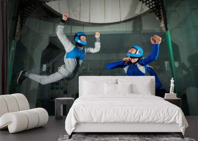 A man and a woman enjoy flying together in a wind tunnel. Free fall simulator Wall mural