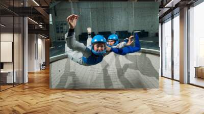 A man and a woman enjoy flying together in a wind tunnel. Free fall simulator Wall mural