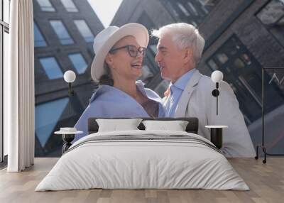 An elderly couple in love walks through the city. Portrait of a stylish gray-haired man and woman.  Wall mural