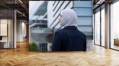 Back view of business woman in hijab and suit on the street.  Wall mural