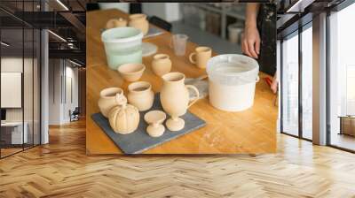 Close-up of a potter's hands glazing a ceramic mug.  Wall mural