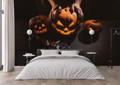 Close-up of female hands holding a halloween pumpkin in the dark Wall mural