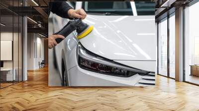 Process of polishing white car hood surface using orbital polishing machine.  Wall mural