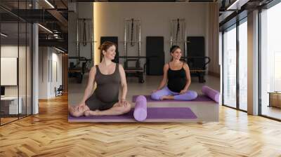 Two pregnant women doing yoga. Preparing for the birth of a child.  Wall mural