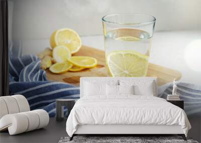 Refreshing drink with lemon on a gray background. Warm water with a slice of lemon next to a blue napkin Wall mural