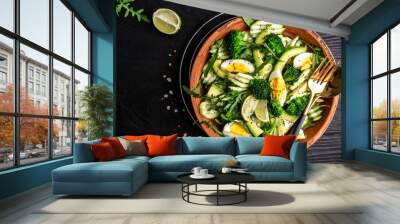 Green salad with avocado, cucumber, broccoli and egg. Healthy organic vegan salat with sliced avocado. Delicious breakfast or snack, Clean eating, dieting, vegan food concept. top view Wall mural