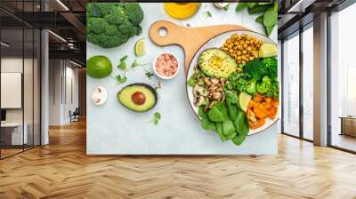 healthy vegan lunch bowl with Avocado, mushrooms, broccoli, spinach, chickpeas, pumpkin on a light background. vegetables salad. Top view Wall mural