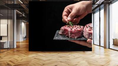 Preparing fresh beef or pork on a dark background. Chef salts steak in a freeze motion with rosemary and spices. Long banner format. Wall mural