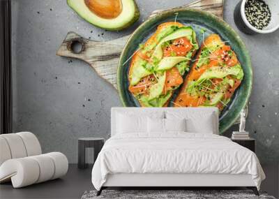 two toasts with salted salmon, guacamole avocado and fresh greens on plate. superfood concept. Healthy, clean eating. Vegan or gluten free diet. top view Wall mural