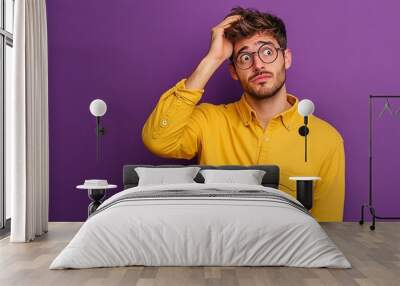 Photo of confused stressed man wear trendy yellow clothes arm touch head isolated on purple color background Wall mural