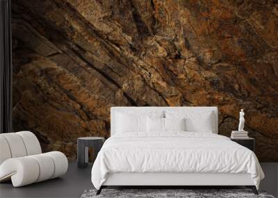 Brown rock texture with cracks. Rough mountain surface. Close-up. Stone background for design. Wall mural