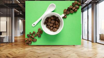 white cup and spoon on a green background, coffee grains. Good morning concept Wall mural