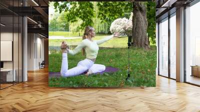 young girl doing yoga in the park in nature in summer Wall mural