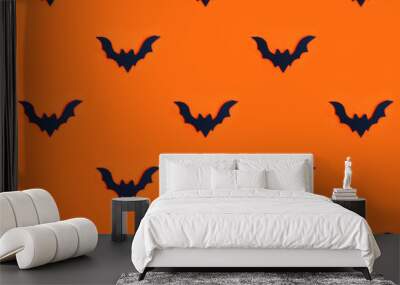 Seamless pattern black silhouette of a bat on orange. Wall mural