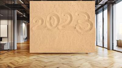 The year 2023, written on the sand of the beach, a New Year's greeting card for travel, a place for text Wall mural