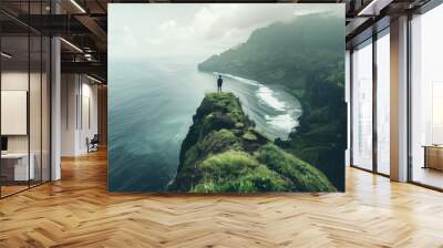 Person on cliff gazes at ocean blending with cloudy sky Wall mural