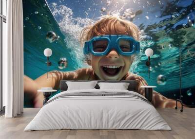 A happy boy swims and dives underwater, wearing diving glasses. having fun in the pool underwater. Active healthy lifestyle, water sports and swimming lessons during the summer holidays Wall mural