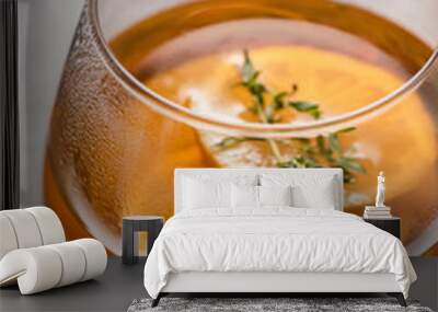 Hot tea in a glass with lemon and thyme close-up, side light. Autumn and winter traditional drinks. Wall mural