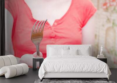 The girl whose face is not visible holds an empty fork in her hands Wall mural