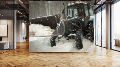 Tractor removes snow. Heavy machinery in winter. Bucket with blocks of ice. Wall mural