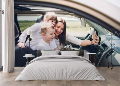 Mother with two children and a dog traveling by car Wall mural