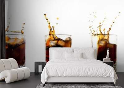 Many glasses of cola with splash and ice cubes on white. Wall mural