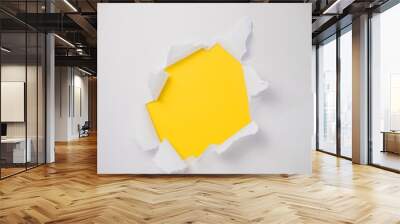 The abstract is full of holes with a white paper on yellow background for concept design with space for your text. A torn piece of paper. Wall mural