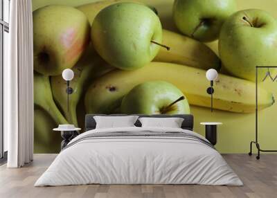 juicy apples and ripe bananas on a yellow background close up Wall mural