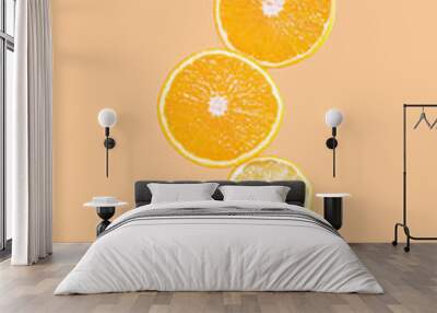 Cut in half lemons and oranges and a woman's hand on a pastel background. Surreal levitation effect. Citrus, vitamin C, fruit concept. Wall mural