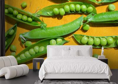 Ripe peas in pods on a yellow wooden background. The concept of summer, pea crop, healthy vitamin food. Wall mural