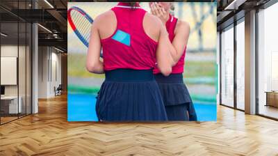 A girl plays tennis on a court with a hard blue surface on a summer sunny day Wall mural