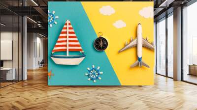 Flat lay sailing ship and airplane on yellow and blue background Wall mural