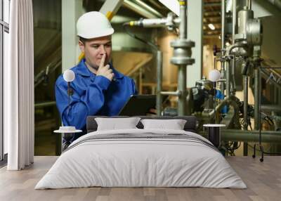 food factory worker is holding a tablet and thinking at plant near the equipment Wall mural