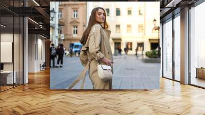 happy young woman walks in the center of a European city in autumn.  Wall mural