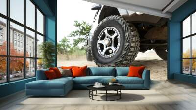 SUV wheel close up is on nature background in summer. mud tire close up is on off road car.  Wall mural