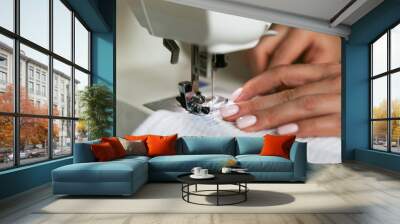 woman's hands sew on a sewing machine close up Wall mural