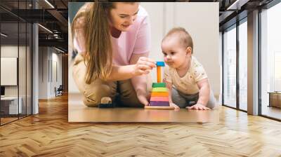 Baby plays with mom. Early development, first games and toys for a baby up to a year Wall mural