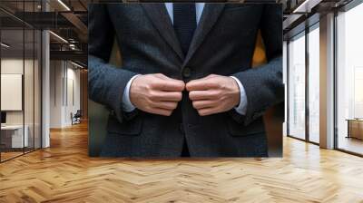 A man adjusts his suit jacket while standing in an elegant urban setting during early evening light Wall mural