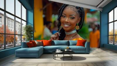 Young woman smiles brightly while wearing traditional attire with intricate braids at a vibrant outdoor market during the day Wall mural