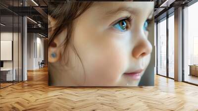 closeup of little girl with earrings on ear Wall mural