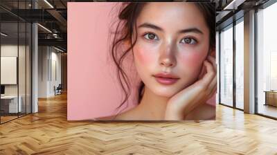 portrait of young beautiful woman of Asian appearance with pink blush on face on pink background Wall mural