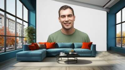 smiling caucasian man about 30 years old in green t- shirt on white background, male portrait Wall mural