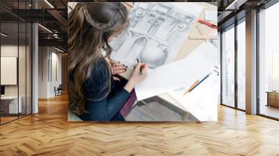 the top view of the female architect designer draws sketches in pencil on white paper. Black and white drawing of an architectural element Wall mural