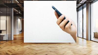 A person is holding a phone and tapping the screen on a white background with copy space. Concept of lifestyle business and Internet technologies in the office Wall mural