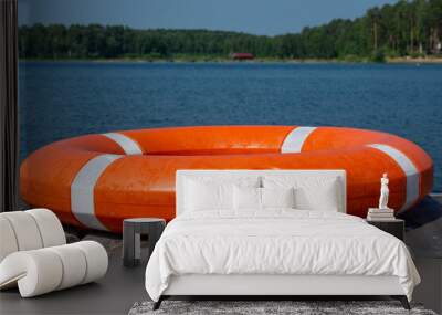 The lifebuoy is lying on a wooden pier. The concept of saving drowning Wall mural