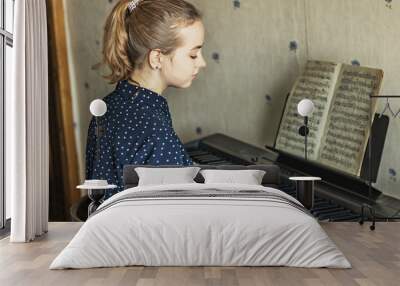 Young girl pianist in the process of playing the piano. Plays classical music. Lifestyle. Wall mural