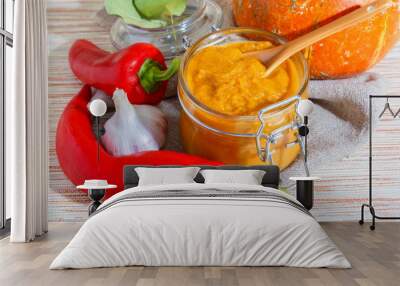 Home-made canning of the autumn harvest, vegetable vegetarian diet healthy food, spicy mashed caviar from orange pumpkin, carrots and zucchini with garlic, red fresh pepper in a glass jar Wall mural