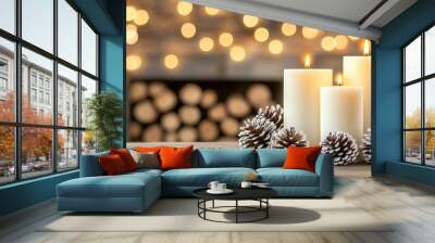 Three lit white candles stand surrounded by pine cones and shimmering decorations, embodying a cozy winter evening by a softly glowing fireplace Wall mural