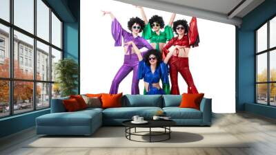 A group of girls in colorful flared suits and afro wigs pose against a white background. Disco style from the eighties or seventies. Wall mural